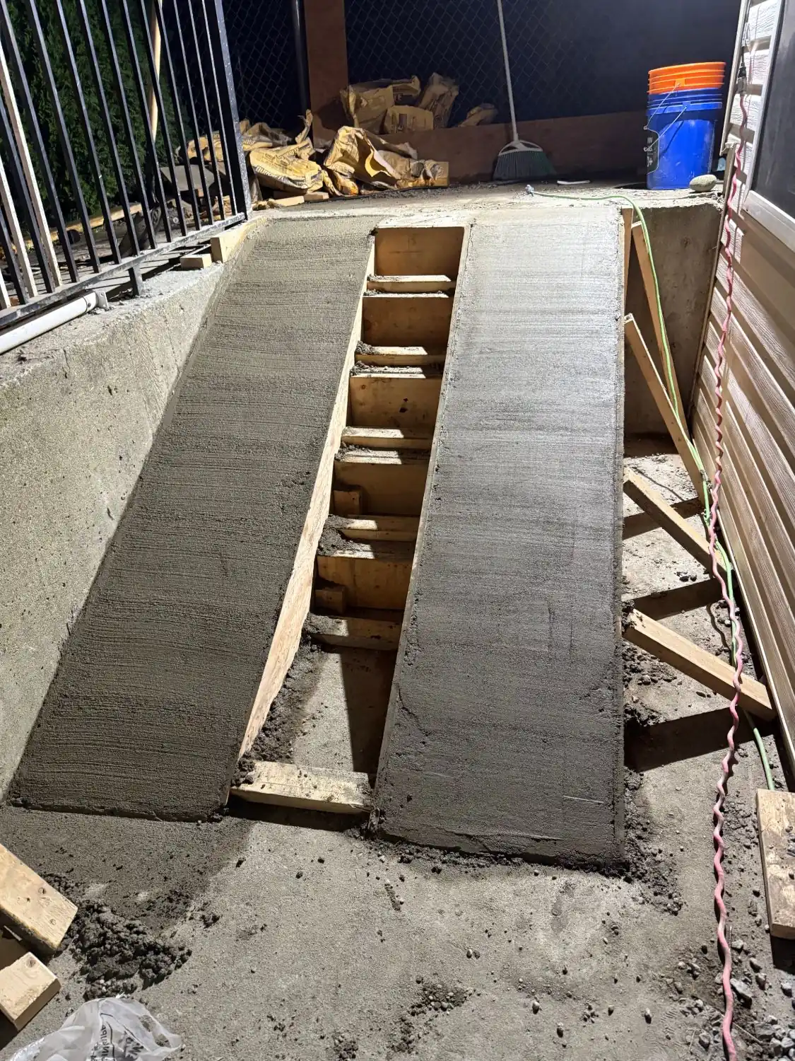 Two freshly poured concrete ramps in Cloverdale, with the formwork for steps between them